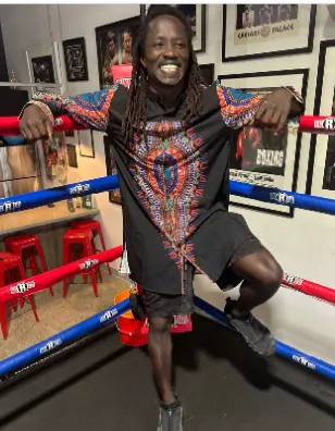 Coach Godfrey smiling inside the boxing ring
